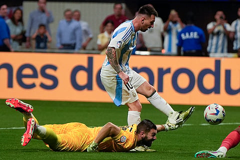 Lionel Messi and Canada's goalkeeper battle for the ball
